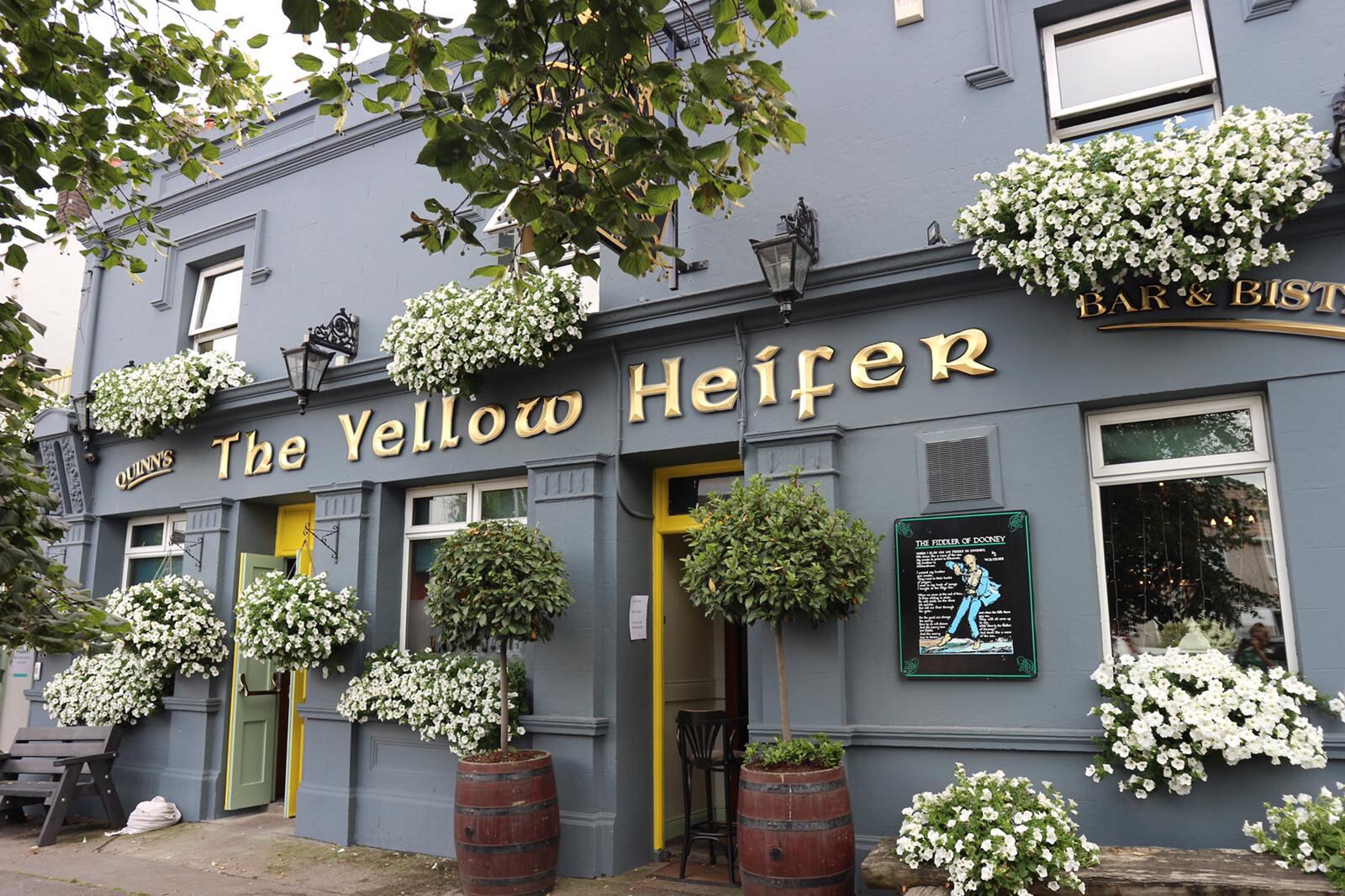 The Yellow Heifer frontage on Main Street with hanging baskets and yellow doors